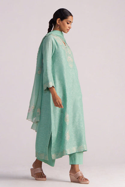 Woman wearing a Dusty Jade Green Woven Silk Kurta Set with a matching dupatta on a plain background