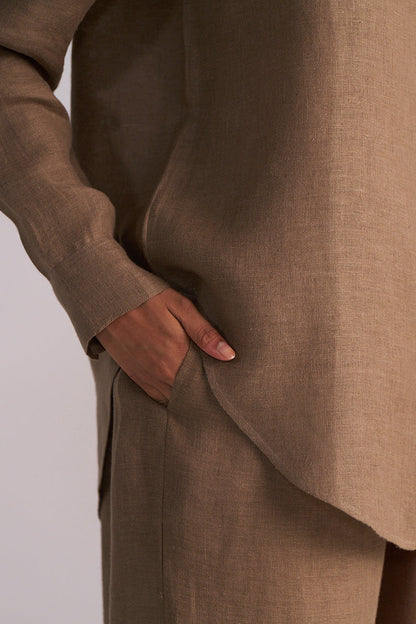 Woodsmoke Brown Pure Linen Co-ord Set with a hand in the pocket on a light gray background