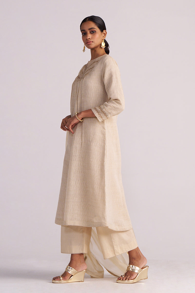 Woman wearing a Beige Woven Kurta Set on a light gray background
