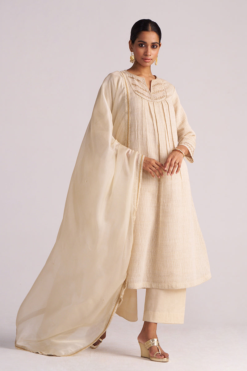 Woman wearing a Beige Woven Kurta Set outfit with a long drape on a white background