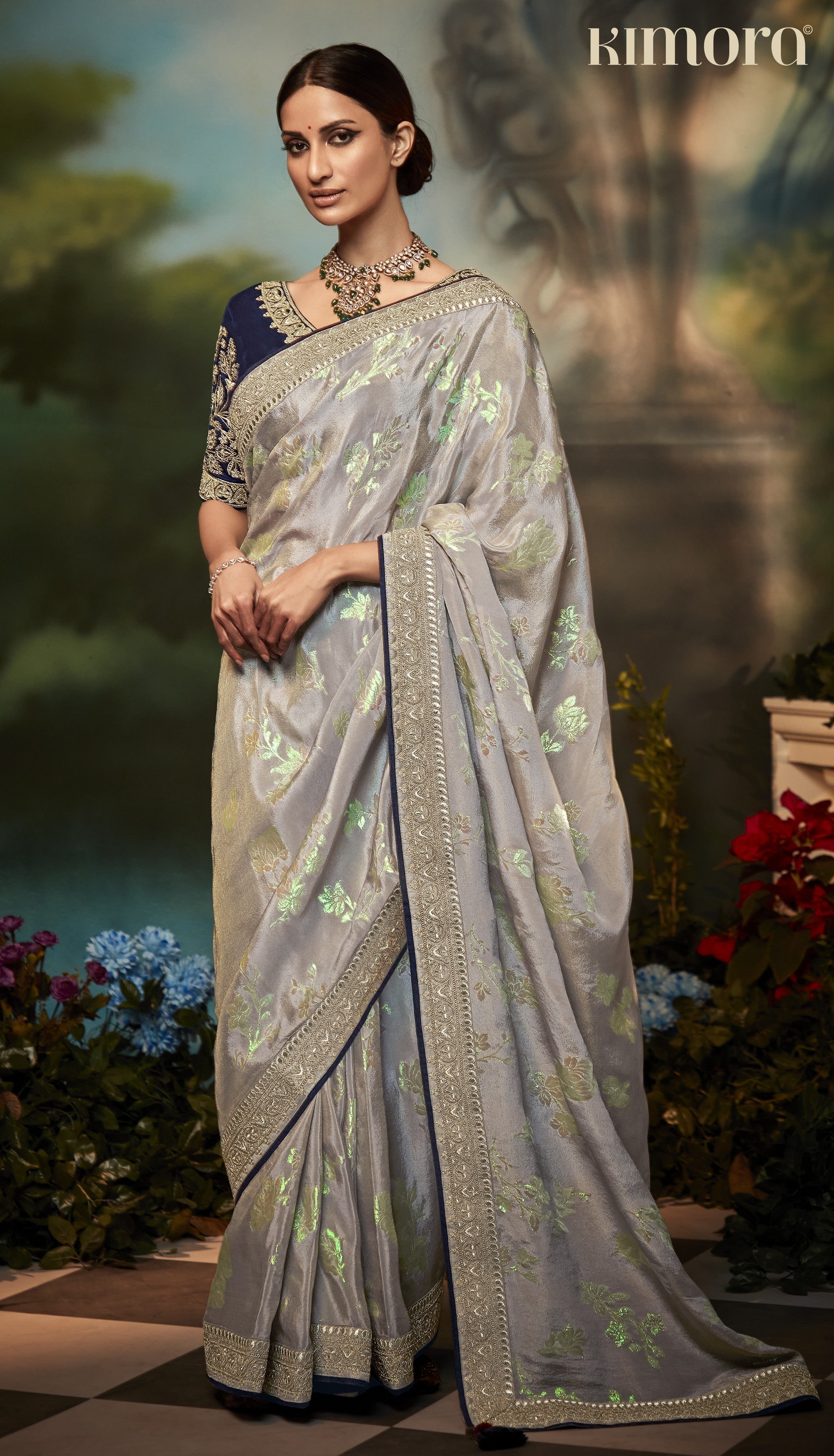 Dhiyona KM Women Pastel Grey Silk Saree With Floral Zari Work And Royal Blue Embroidered Blouse “ Kimora