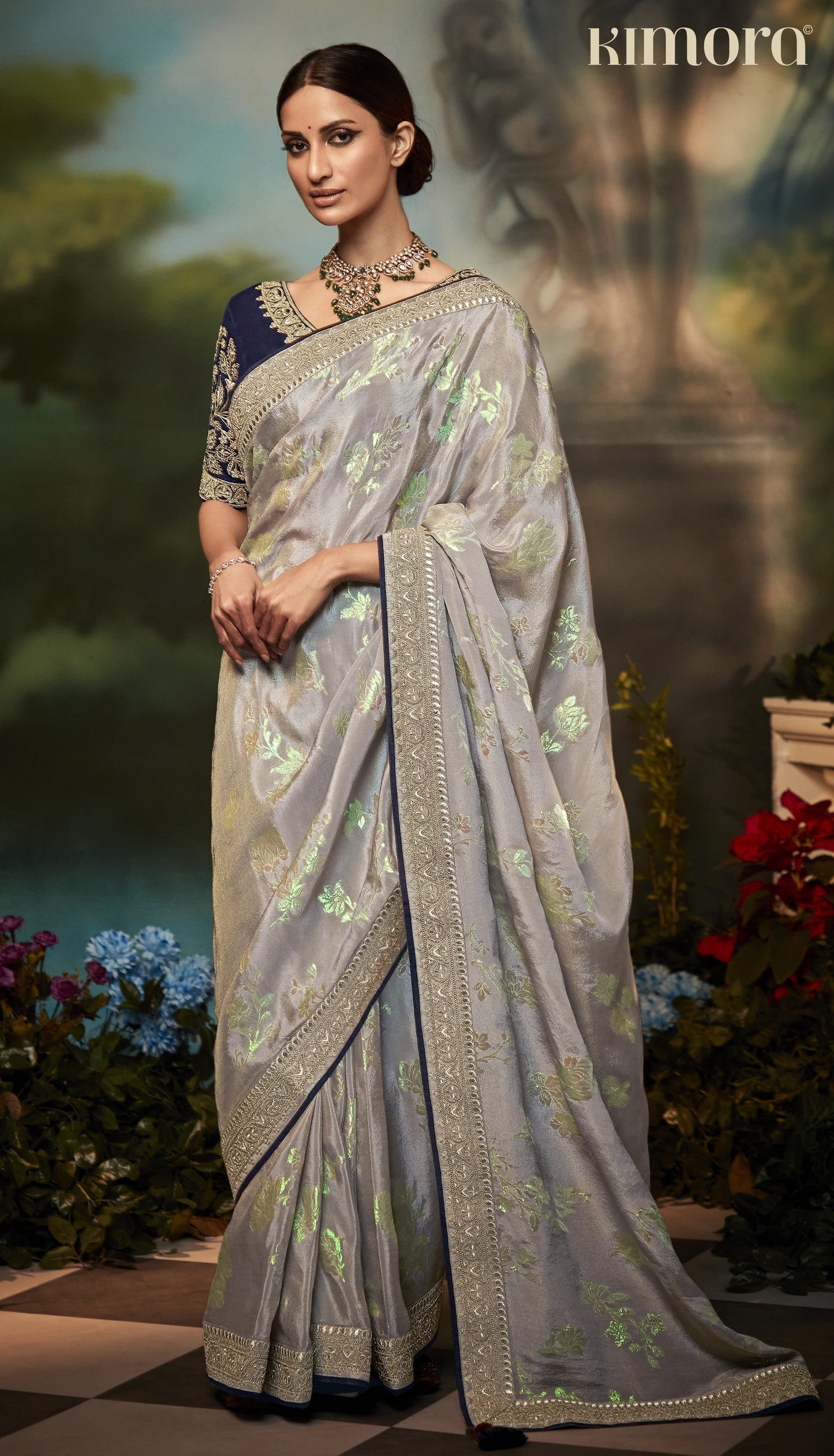 Dhiyona KM Women Pastel Grey Silk Saree With Floral Zari Work And Royal Blue Embroidered Blouse “ Kimora