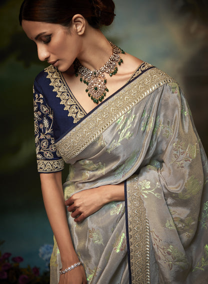 Dhiyona KM Women Pastel Grey Silk Saree With Floral Zari Work And Royal Blue Embroidered Blouse “ Kimora